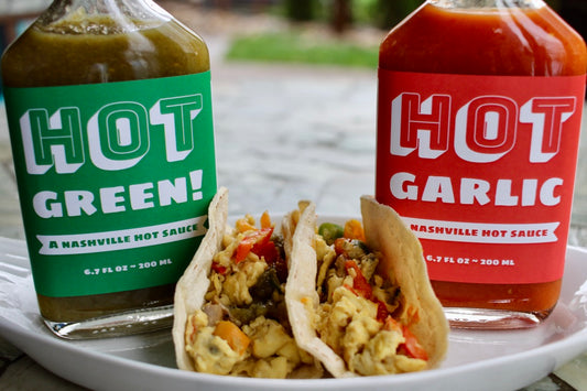 breakfast tacos with hot green hot sauce and hot garlic hot sauce